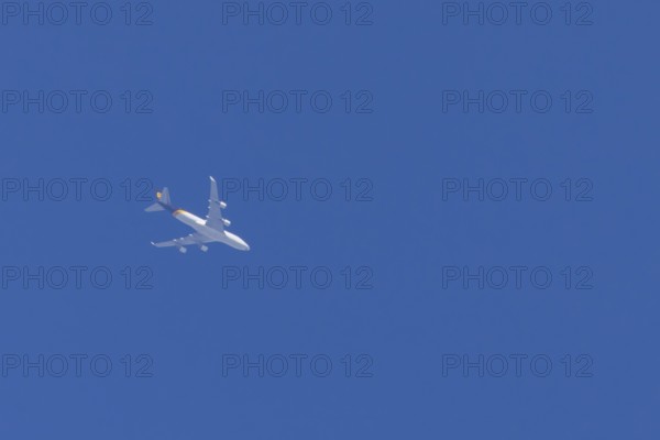 Boeing 747 jumbo jet cargo aircraft of UPS United Postal Service flying in a blue sky, England, United Kingdom