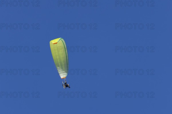 Paraglider flying in a blue sky, England, United Kingdom