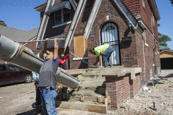 Detroit, Michigan, Workers rebuild front porch of a house they are remodeling in the Morningside neighborhood. The house had been vacant for many years. Detroit lost nearly two-thirds of its residents from 1950 to 2020 but has been growing modestly in recent years