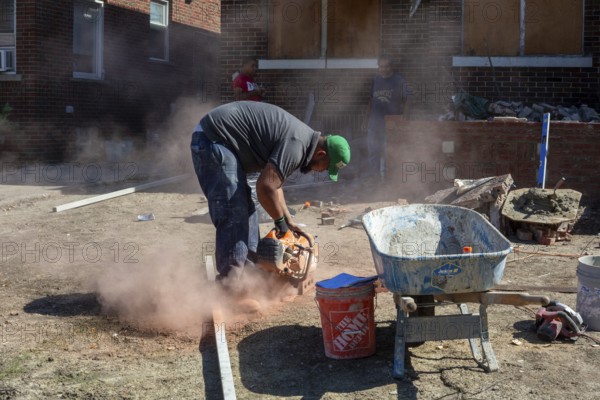 Detroit, Michigan - Workers rebuild the front porch of a house they are remodeling in the Morningside neighborhood. The house had been vacant for many years. Detroit lost nearly two-thirds of its residents from 1950 to 2020 but has been growing modestly in recent years