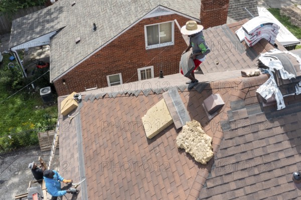Detroit, Michigan - Workers re-roof a house they are remodeling in the Morningside neighborhood that had been vacant for many years. Detroit lost nearly two-thirds of its residents from 1950 to 2020 but has been growing modestly in recent years
