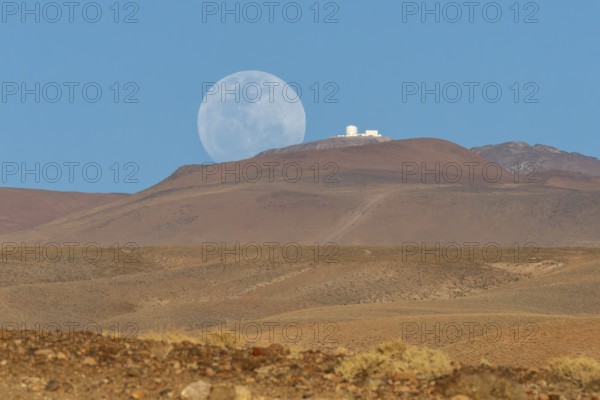 An observatory on a mountain next to the rising full moon, San Pedro de Atacama, San Pedro de Atacama, Región de Antofagasta, Chile