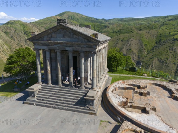 Ancient temple complex with columns and ruins against a green mountain background, aerial view, Temple of Garni, Garni, Kotayk Province, Armenia