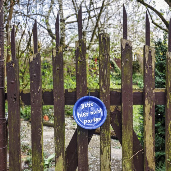 Funny sign at the old garden gate, blue plate with inscription, Please do not park here, Hanover, Lower Saxony, Germany