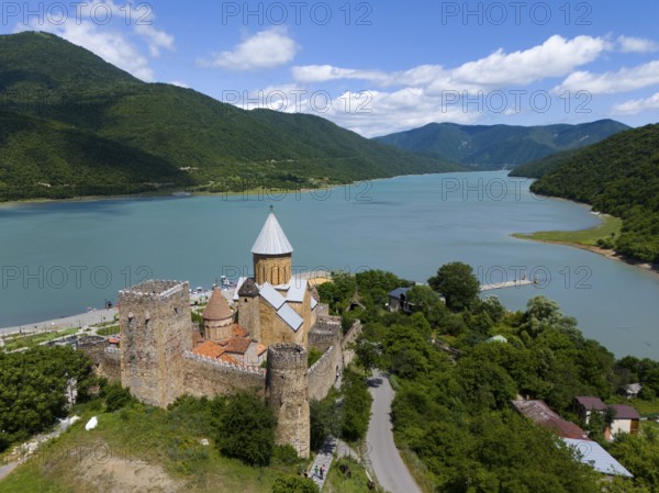 Medieval castle on the river surrounded by green mountains under a cloudy sky, aerial view, Ananuri castle, Zhinvali reservoir, Shinvali, Jinvali or Shinvali, Mtskheta-Mtianeti region, Georgian Military Road, Georgia