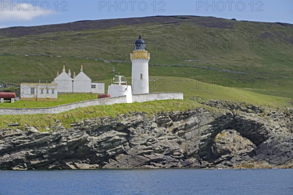 Lighthouse and building on green coastal landscape above the sea, Stevenson family, Noss, Shetland Islands, Scotland, Great Britain