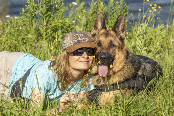 Woman and her German Shepherd lying in the grass, Woman and her German Shepherd lying in the grass, Sunny day, Gaspesie Region, Province of Quebec, Canada, North AmericaGaspesie Region, Province of Quebec, Canada, North America