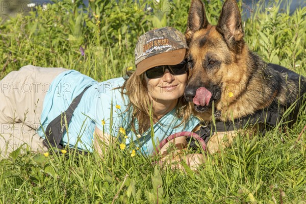 Woman and her German Shepherd lying in the grass, Sunny day, Gaspesie Region, Province of Quebec, Canada, North America