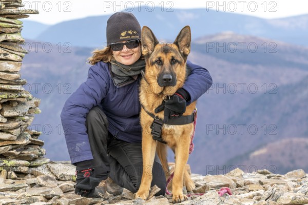 Woman and her German Shepherd sitting on a mountain top, Gaspesie Region, Province of Quebec, Canada, North America