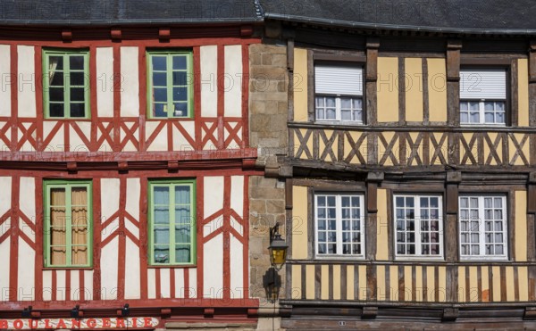 Two half-timbered houses in contrasting colours, windows with green frames, Tréguier, Brittany, France