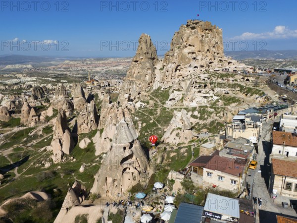 Combination of rock formations and modern buildings under a blue sky in a Turkish town, aerial view, Uchisar Castle, Uçhisar Kalesi, impressive rock formation and fortress, Göreme National Park, Göreme Tarihî Millî, Nevsehir Province, Nevsehir, Cappadocia, Cappadocia, Kapadokya, Cappadocia, Central Anatolia, Turkey