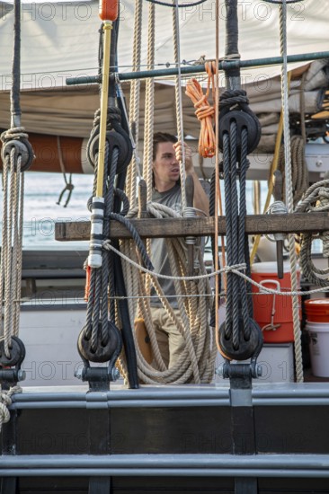 Detroit, Michigan - 9 August 2025 - Four schooners visit Detroit for the Sail Detroit Festival. A crew member handles the rigging on the Ernestina-Morrissey, which began sailing in 1894 and has since been restored