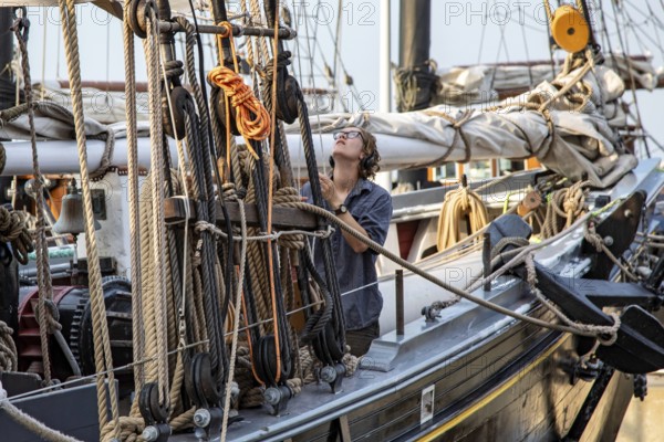 Detroit, Michigan - 9 August 2025 - Four schooners visit Detroit for the Sail Detroit Festival. A crew member handles the rigging on the Ernestina-Morrissey, which began sailing in 1894 and has since been restored