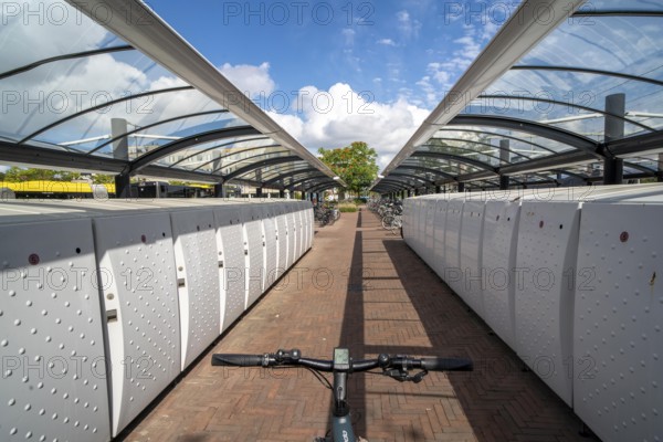 Bicycle parking spaces and boxes on the cycle path in the east of Utrecht, at Utrecht-Lunetten railway station, direct connection of the cycle path to the railway station and bus station, covered bicycle stands, on the Maarschalkerweerdpads cycle path, Netherlands