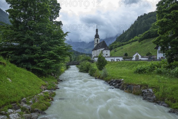 St Sebastian in Ramsau in Berchtesgadener Land with rain clouds after heavy rain