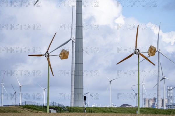 Mini wind turbines, from the Dutch company Ecoways EAZ wind turbine, produces up to 15 kW power and up to 45, 000 KW electricity per year, for self-consumption, intended primarily for farms, rotors made of wood, from forests in the Netherlands, easy to recycle, quick and easy to set up, for cheap power supply in the countryside, behind it large wind turbines of a wind farm near Eemshaven, Netherlands
