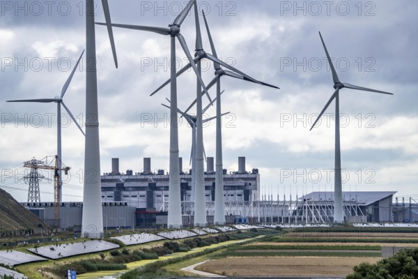 Wind turbines of a wind farm near Eemshaven, behind the Eemscentrale gas and steam power station, solar park on a dyke, Netherlands