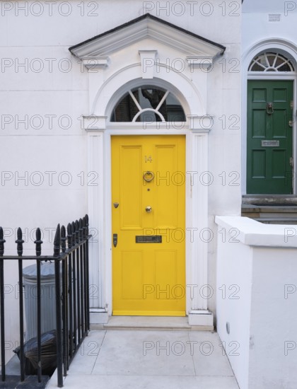 Bright yellow front door with neoclassical triangular pediment, Palladian-style entrance, white façade, Kensington, London, England, United Kingdom