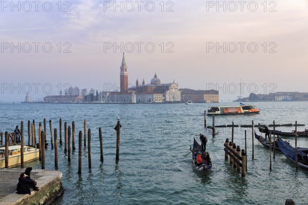 Boat dock at St Mark's Square, San Giorgio Maggiore church in the background, evening sky, Venice, Italy