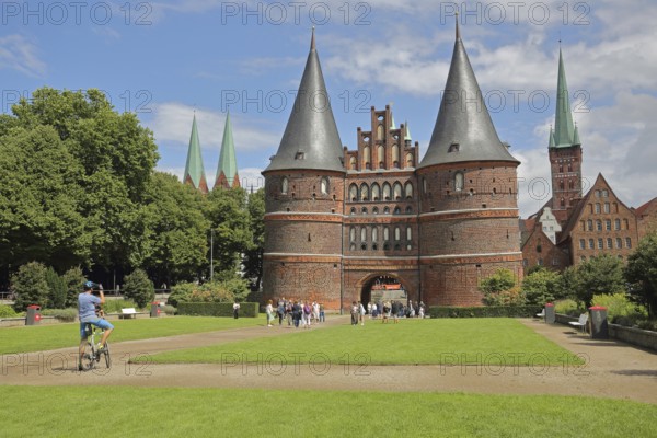 Historic Holsten Gate and pedestrians, tourists, photograph, St. Mary's Church, Lübeck St. Peter's Church Tower, Brick Gothic, brick building, city gate, towers, landmark, Holsten Gate Square, Old Town, Lübeck, Schleswig-Holstein, Germany