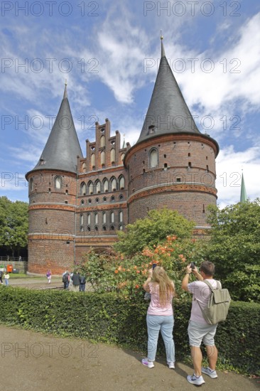 Historic Holsten Gate and tourists taking photos, Brick Gothic, Brick building, City gate, Landmark, Holsten Gate Square, Old Town, Lübeck, Schleswig-Holstein, Germany