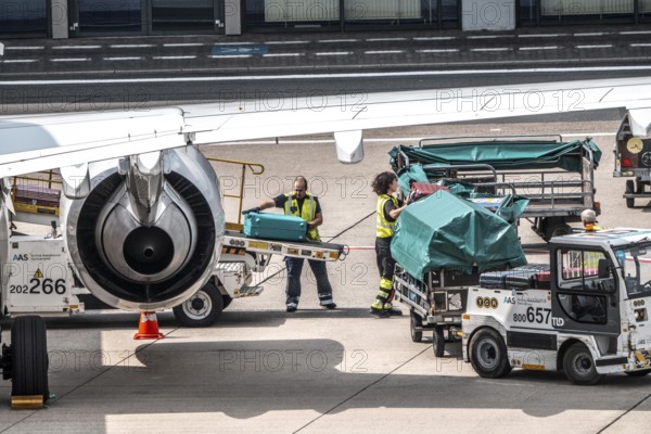 Aircraft being unloaded after landing, luggage being loaded, Düsseldorf International Airport. Düsseldorf, North Rhine-Westphalia, Germany