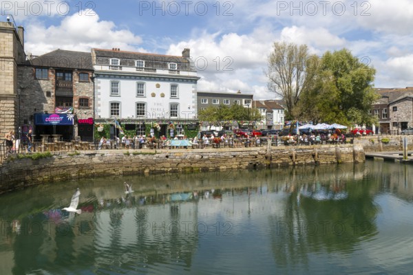 People sitting outside The Three Crowns pub quayside harbour, The Barbican, Plymouth, Devon, England, UK