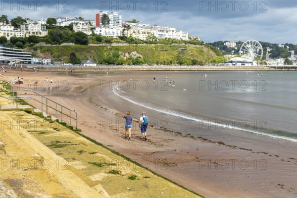 People walking on Torre Abbey Sands sandy beach, Torquay, Devon, England, UK