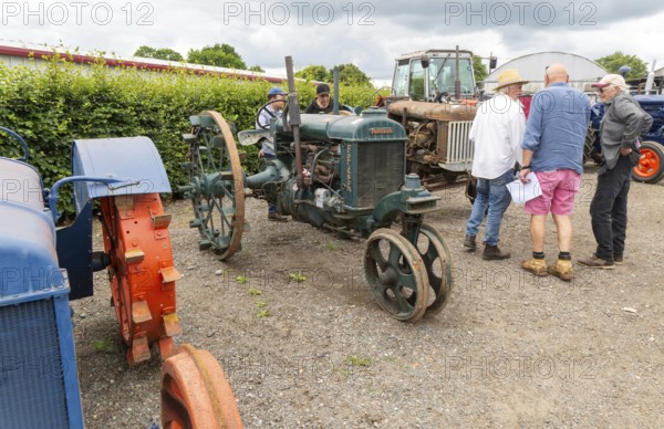 People viewing vintage Fordson tractors on display at auction, UK