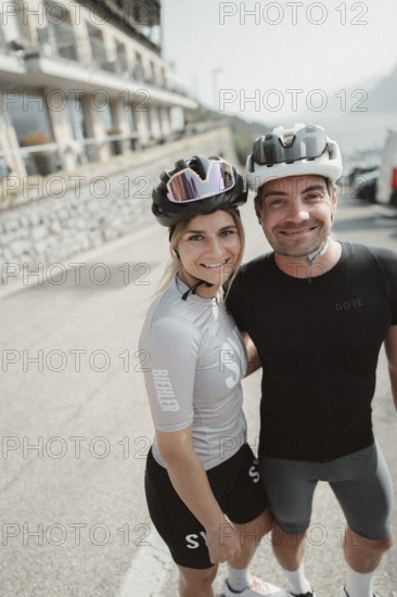 Woman and man riding racing bikes in Italy on Lake Garda