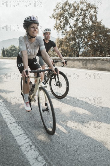 Woman and man riding racing bikes in Italy on Lake Garda
