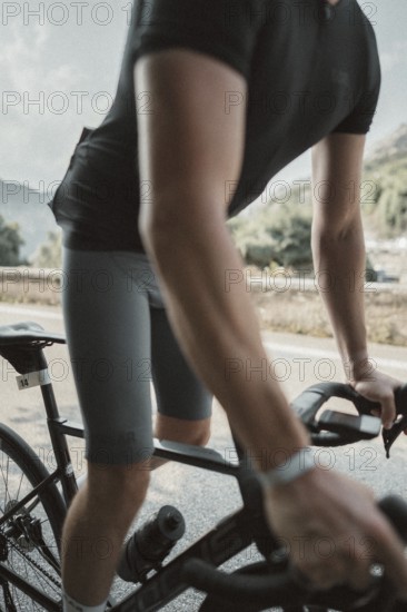 Young man riding a racing bike on Lake Garda. Sunny weather and dolce vita