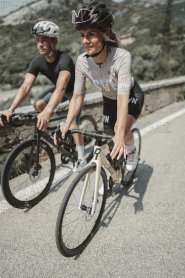 Woman and man cycling on Lake Garda in Italy. Sunny weather and dolce vita