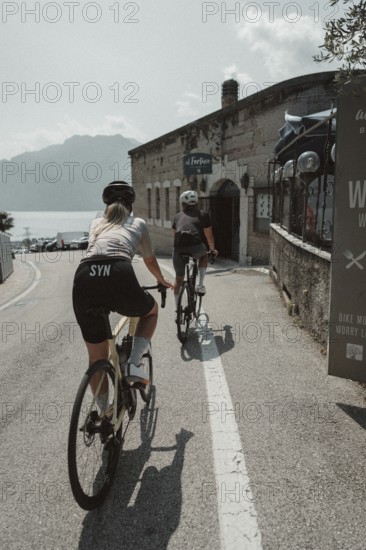 Woman and man cycling on Lake Garda in Italy. Sunny weather and dolce vita