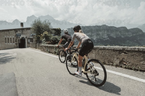 Woman and man cycling on Lake Garda in Italy. Sunny weather and dolce vita