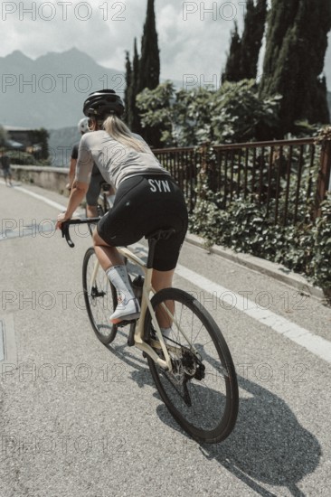Young woman riding a racing bike on Lake Garda. Sunny weather and dolce vita