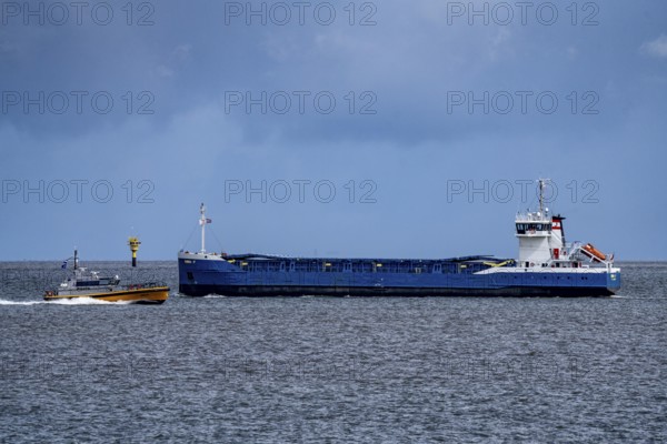 Pilot boat, Milo, pilot boat, brings sea pilots, ship pilots, to the ships to ensure safe entry and exit to the harbour, here in front of the seaport of Eemshaven, freighter Emma F, Ems estuary, Netherlands