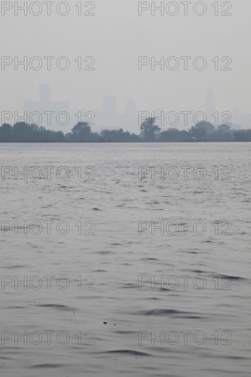 Detroit, Michigan USA - 4 August 2025 - Smoke from Canadian wildfires nearly erases the downtown skyline, as seen from about five miles up the Detroit River. The city's air quality is listed as unhealthy
