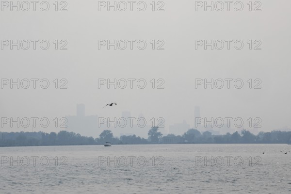 Detroit, Michigan USA - 4 August 2025 - Smoke from Canadian wildfires nearly erases the downtown skyline, as seen from about five miles up the Detroit River. The city's air quality is listed as unhealthy