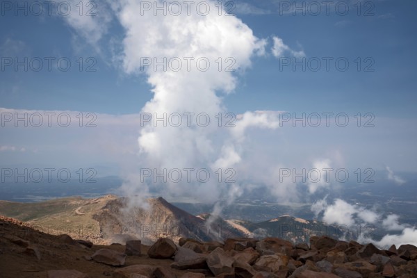 Colorado Springs, Colorado - Clourds rise near the summit of Pikes Peak, a 14, 115' mountain in Colorado's front range. Thousands of tourists visit, most by driving a steep road to the summit, or riding on a cog railway