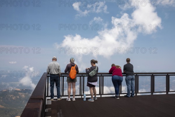 Colorado Springs, Colorado - Tourists line a viewint platform at the summit of Pikes Peak, a 14, 115' mountain in Colorado's front range. Thousands of tourists visit, most by driving a steep road to the summit, or riding on a cog railway