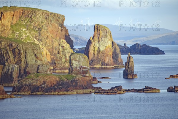 Dramatic coastal landscape with high cliffs, wind turbines and calm sea, Eshaness, Shetland Islands, Scotland, United Kingdom
