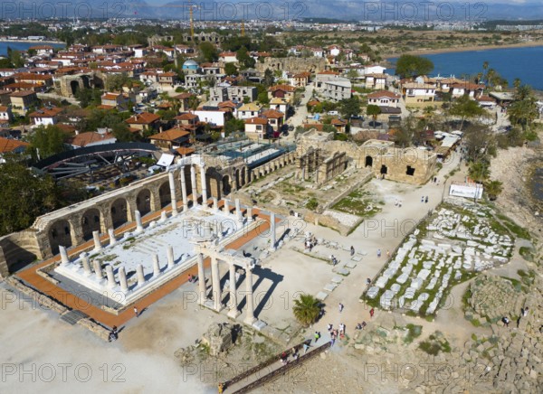 Ancient ruins next to a town overlooking the sea. Historical and scenic scenery, aerial view, Temple of Apollo, Side, Manavgat, Antalya Province, Turkey