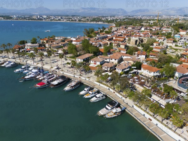 Scenic harbour with boats and palm trees along the coastline of a town, aerial view, harbour, Side, Manavgat, Antalya province, Turkey