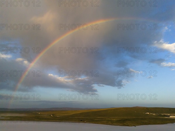 A rainbow stretches across a wide landscape under a colourful sky, aerial view, salt lake, Tuz Gölü, location between Konya, Aksaray and Ankara, Turkey