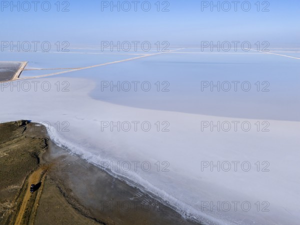 A vast salt landscape stretches out under a clear blue sky, aerial view, salt lake, Tuz Gölü, located between Konya, Aksaray and Ankara, Turkey