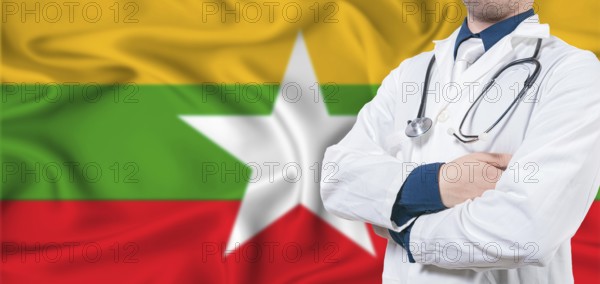 Myanmar healthcare concept. Male doctor on Myanmar flag. Doctor with crossed arms on Myanmar flag