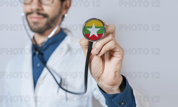 Doctor holding stethoscope with Myanmar flag. Myanmar health and care concept, Myanmar flag on stethoscope