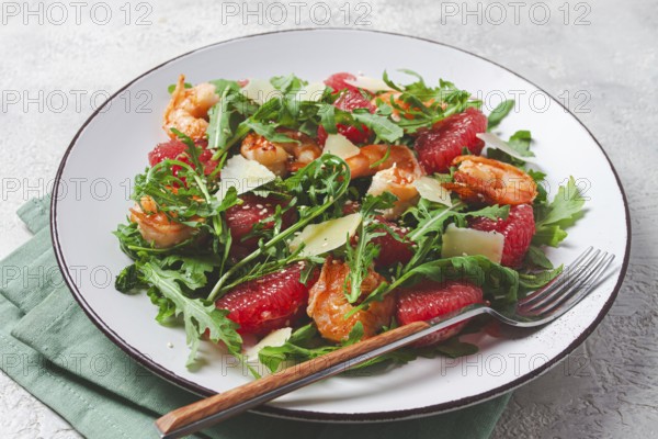 Fresh shrimp salad with arugula, grapefruit, and parmesan served in a bowl
