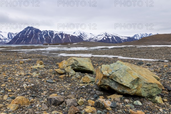 Melting glacier, copper-bearing stones, water, mountain range, Cooper Camp, Spitsbergen, Svalbard